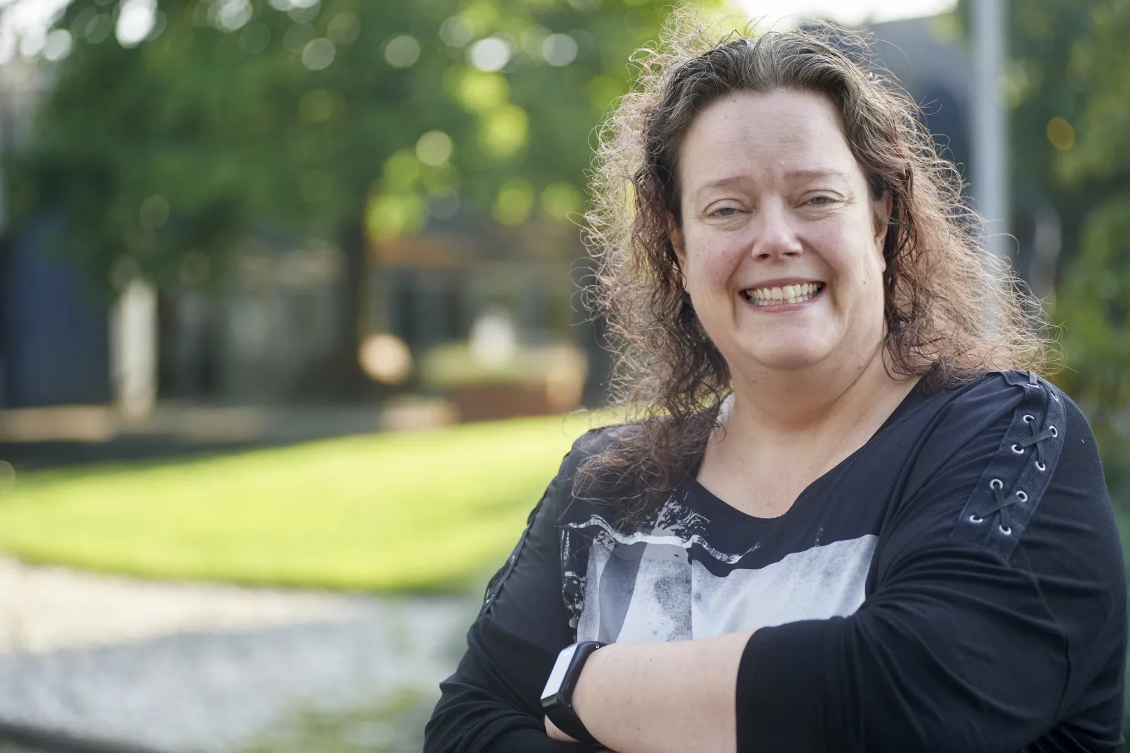 Gonnie lachend voor het pand van IBN